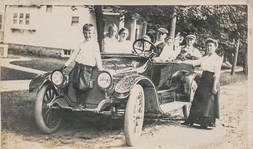 Family posing with their dirty car